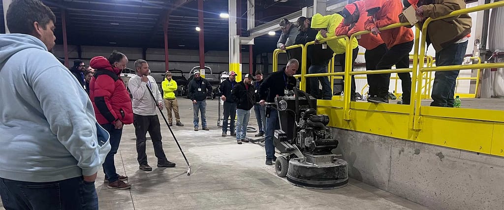 Group of students watching a concrete floor prep training class.