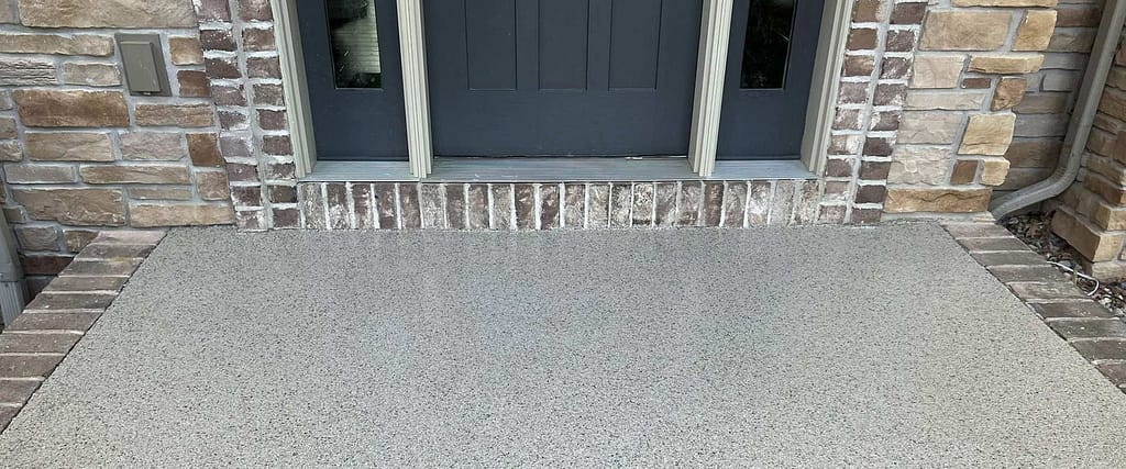 Front entry of a home with a concrete patio coating.