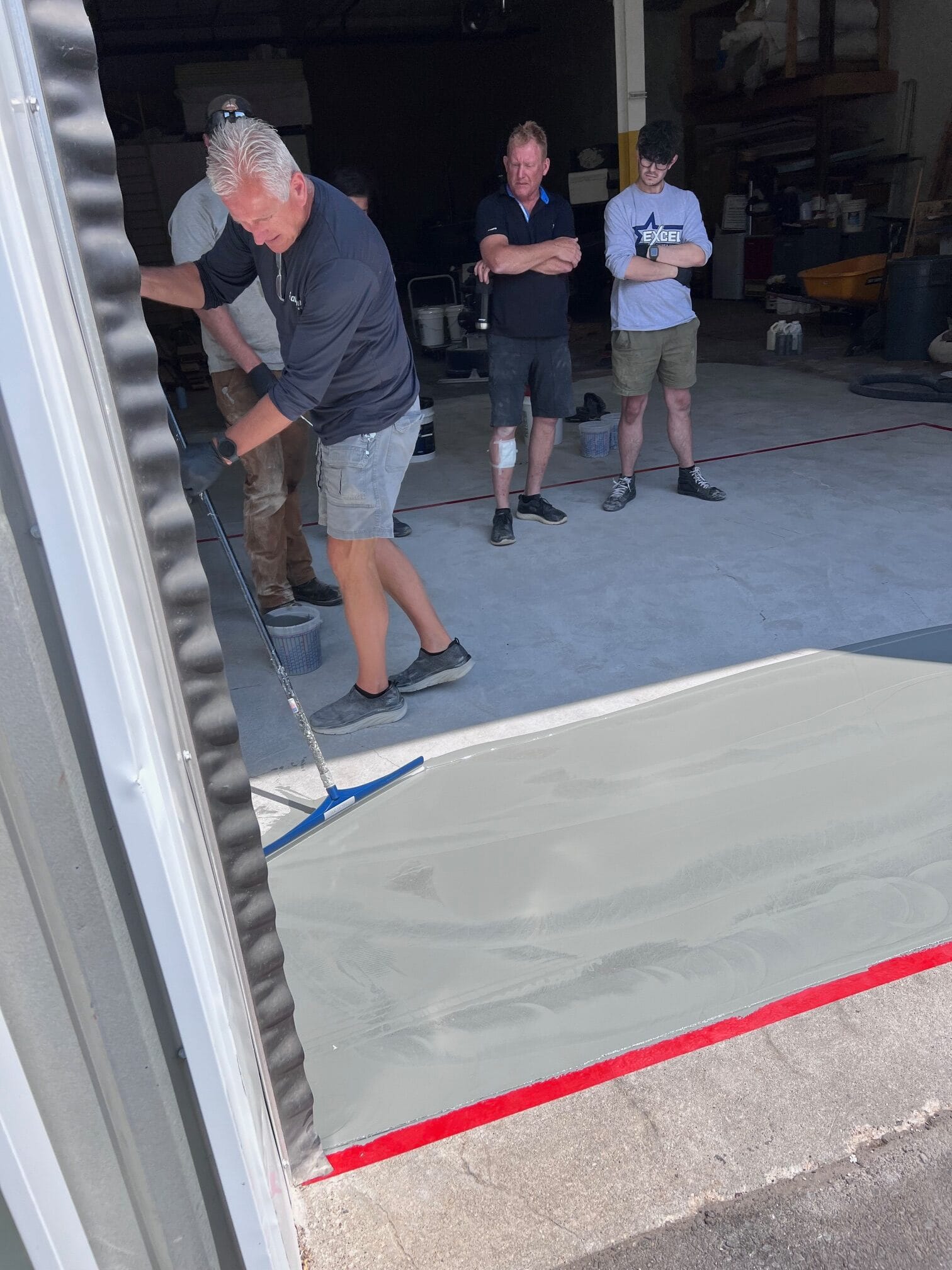 The Co-Owner of AllSource Supply Inc., Roy Magnuson, applying the base coat layer in a warehouse
