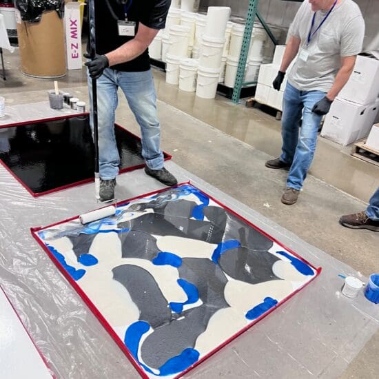 Allsource team demonstrating the metallic floor coating process.