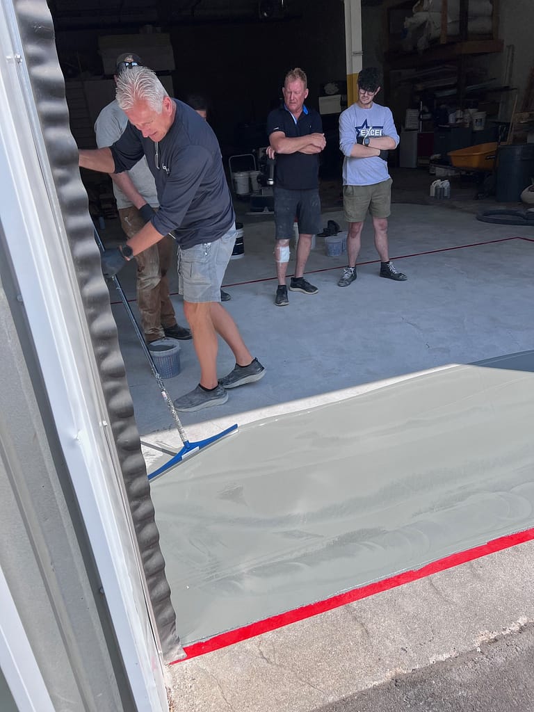 The Co-Owner of AllSource Supply Inc., Roy Magnuson, applying the base coat layer in a warehouse